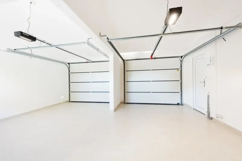 Dos puertas de garaje se abren a un espacio limpio y moderno, listo para pintar el garaje original.